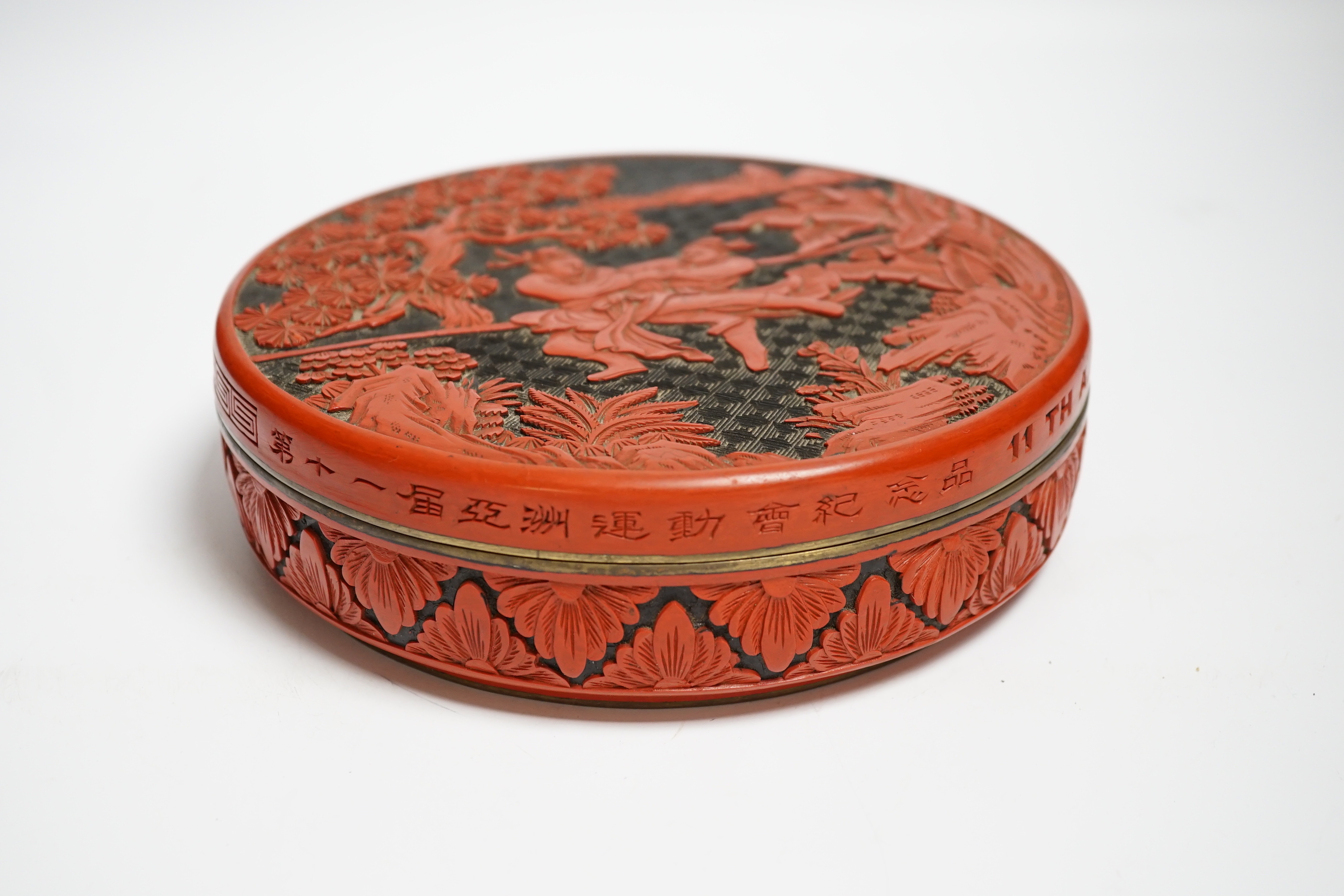 A Chinese cinnabar two colour lacquer box and cover, commemorating 11th Asian Games, Beijing, 20.5cm diameter